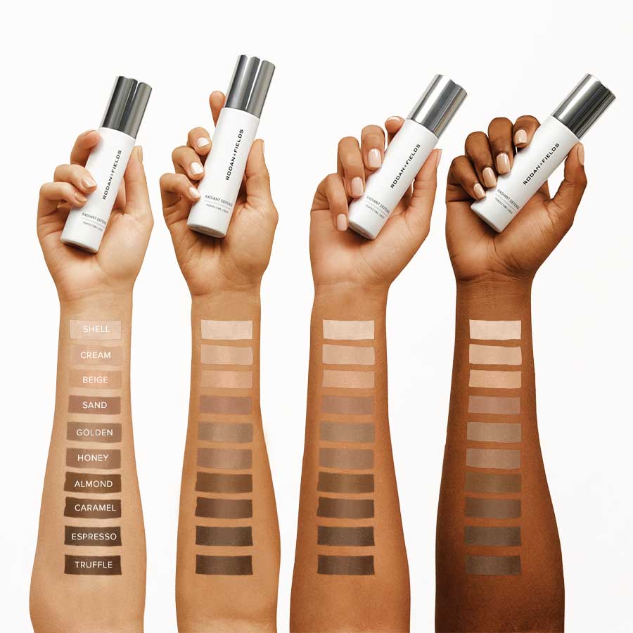Four hands of different skin tones holding Rodan + Fields Radiant Defense Perfecting Liquid SPF 30 with color swatches showing a comparison of every available shade